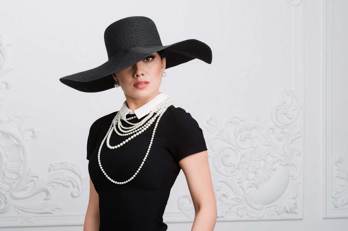 siyah şapkalı inci kolyeli ve siyah elbiseli güzel kadın